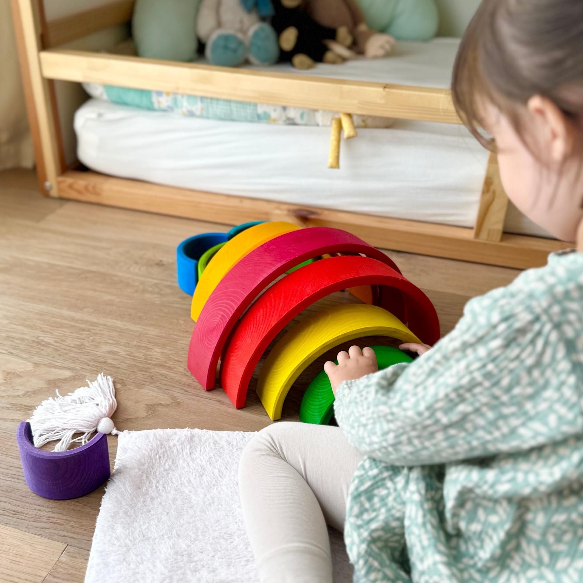 Kinder spielen mit dem großen Montessori Regenbogen aus Holz – fördert Motorik und Kreativität