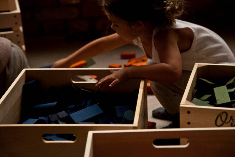 Kinder spielen mit bunten Holzbausteinen aus Naturholz